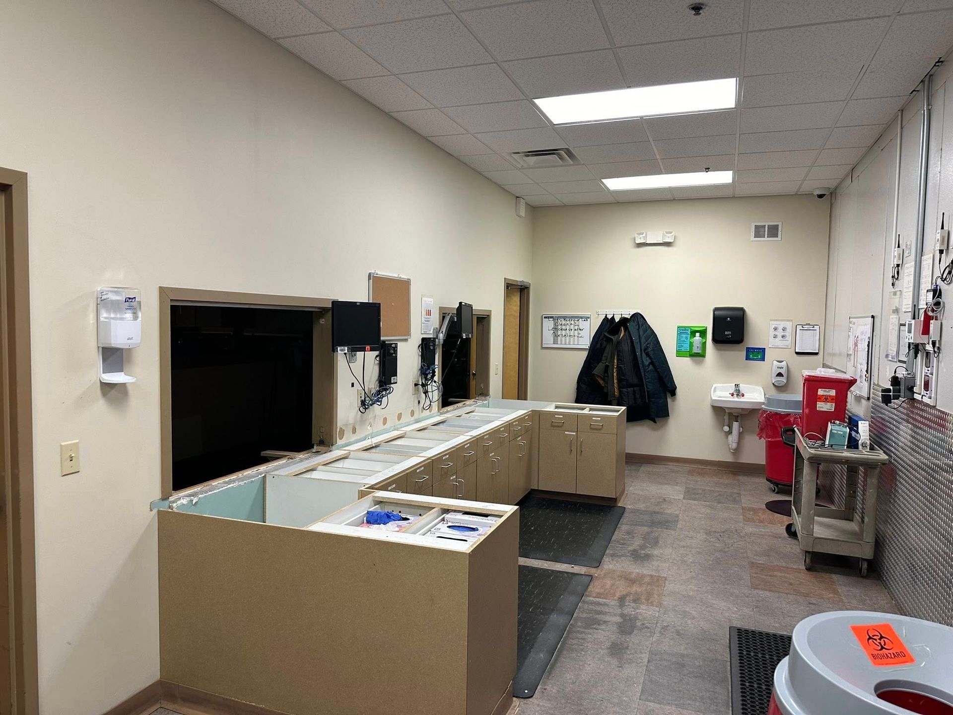 A room with a lot of cabinets and a sink in it.