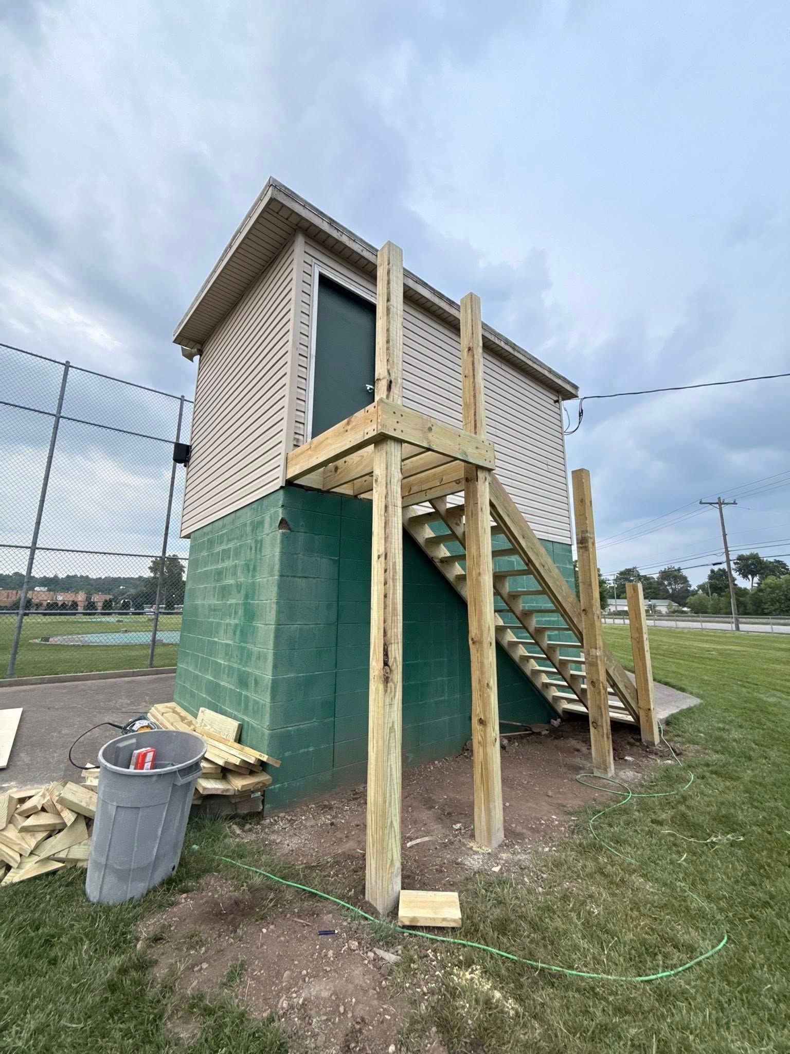 A small house with stairs leading up to it is being built in a field.