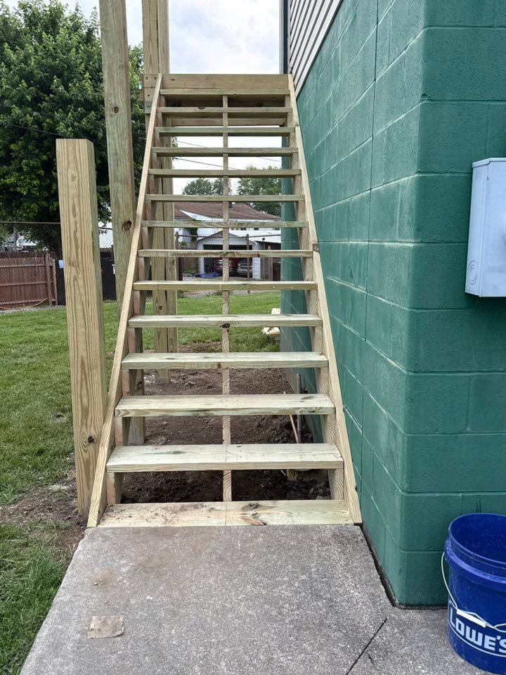 A wooden staircase is being built on the side of a building.
