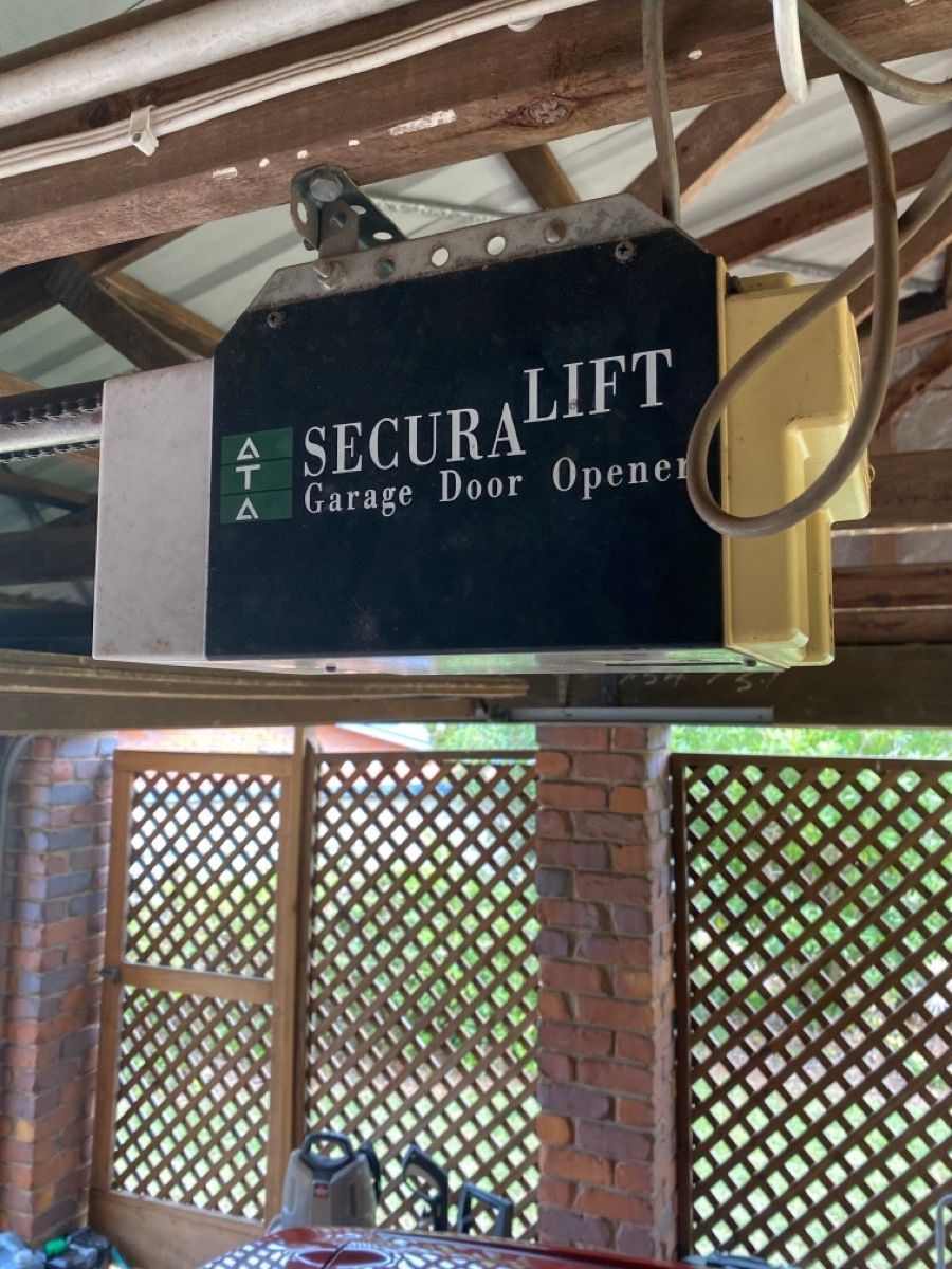 A secura lift garage door opener is hanging from the ceiling