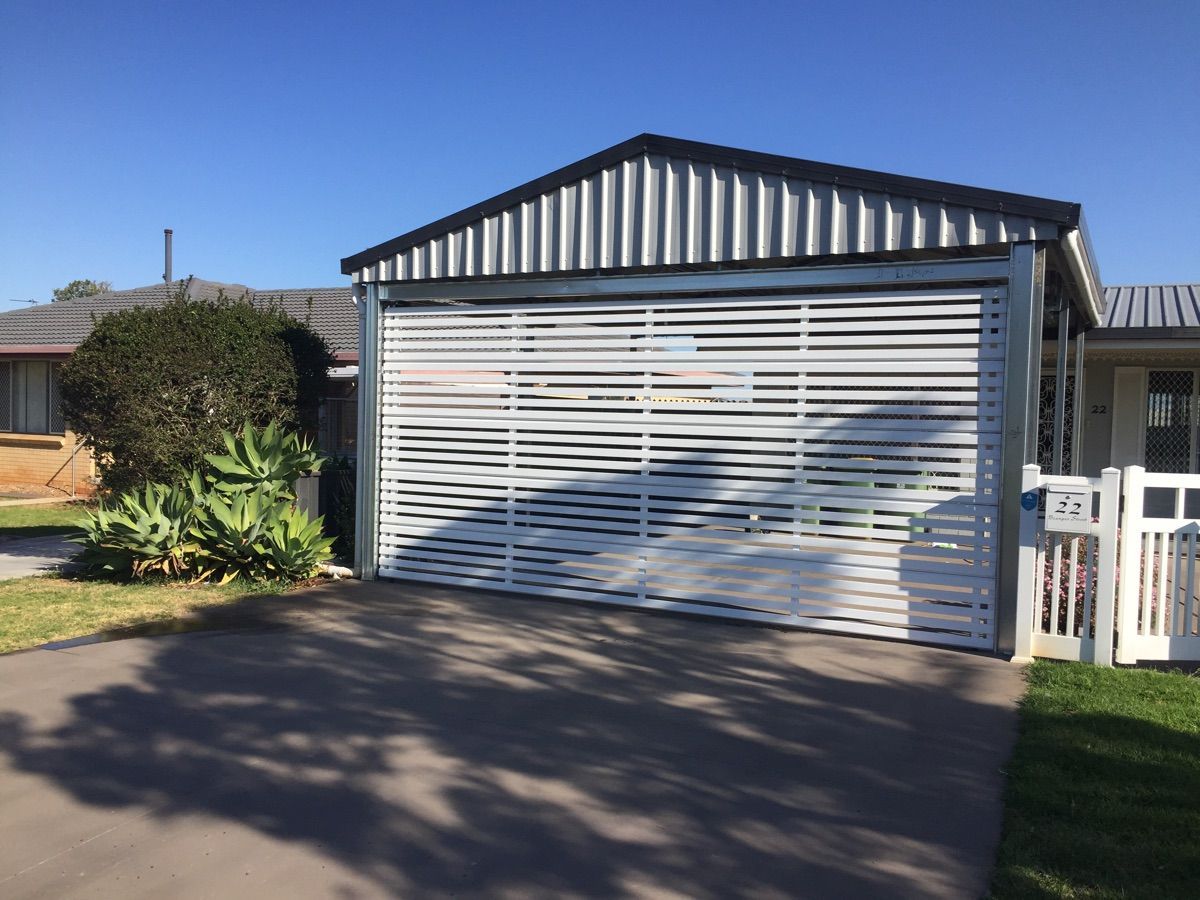 A white garage door is sitting in front of a house.