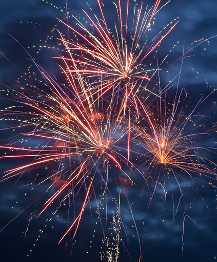 Colorful fireworks bursting in a dark blue night sky