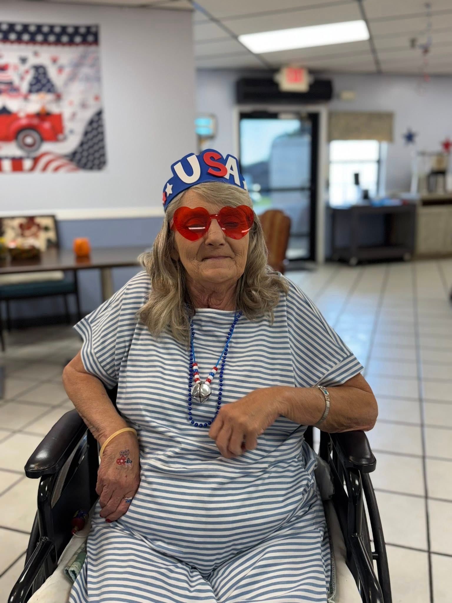 Woman in wheelchair, red heart sunglasses, 