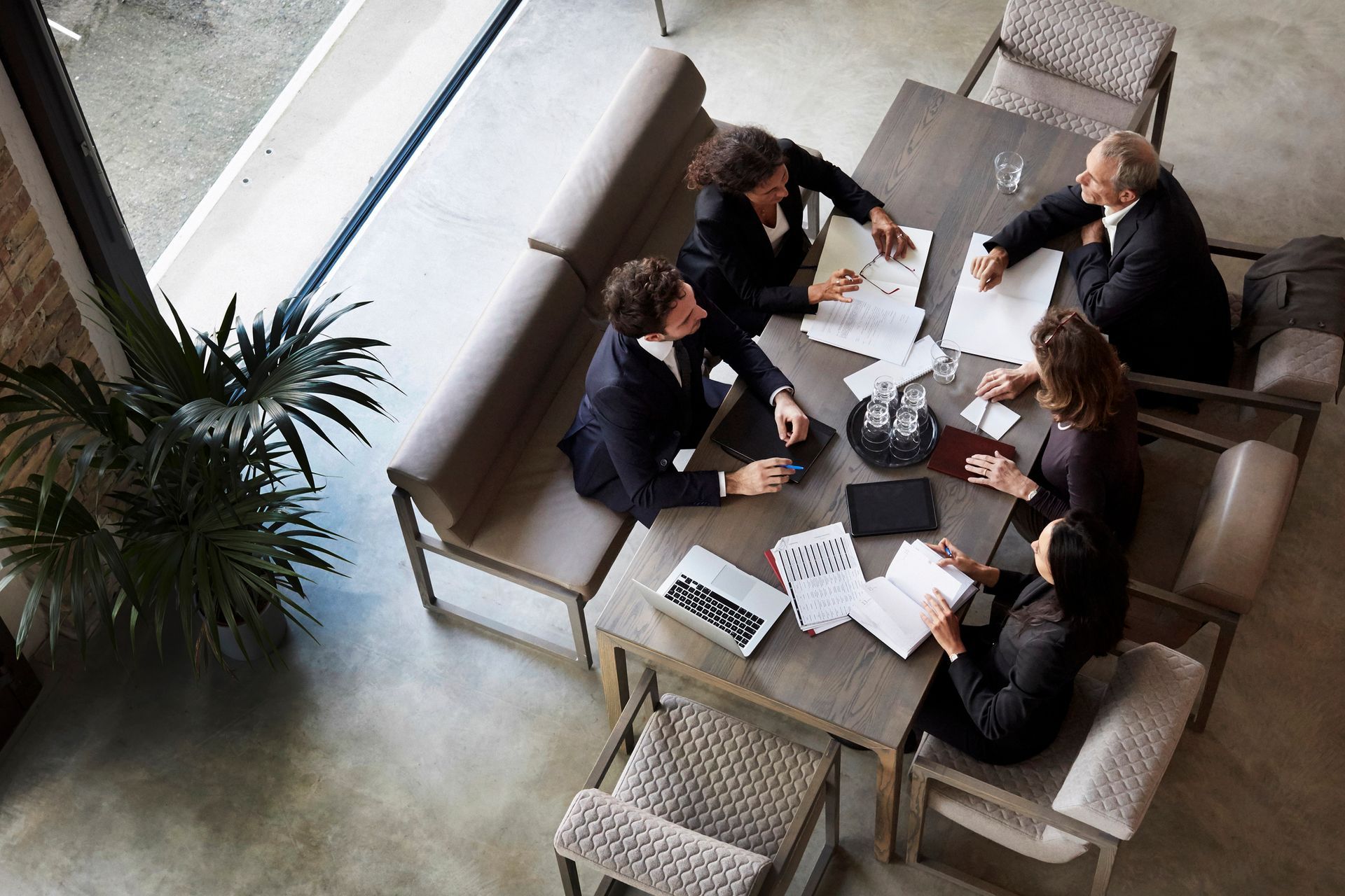 A group of people are sitting around a table having a meeting.