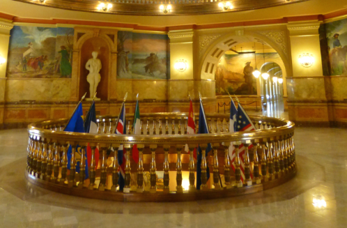 The Kansas Capitol's second-floor rotunda features various flags, murals, and statues.