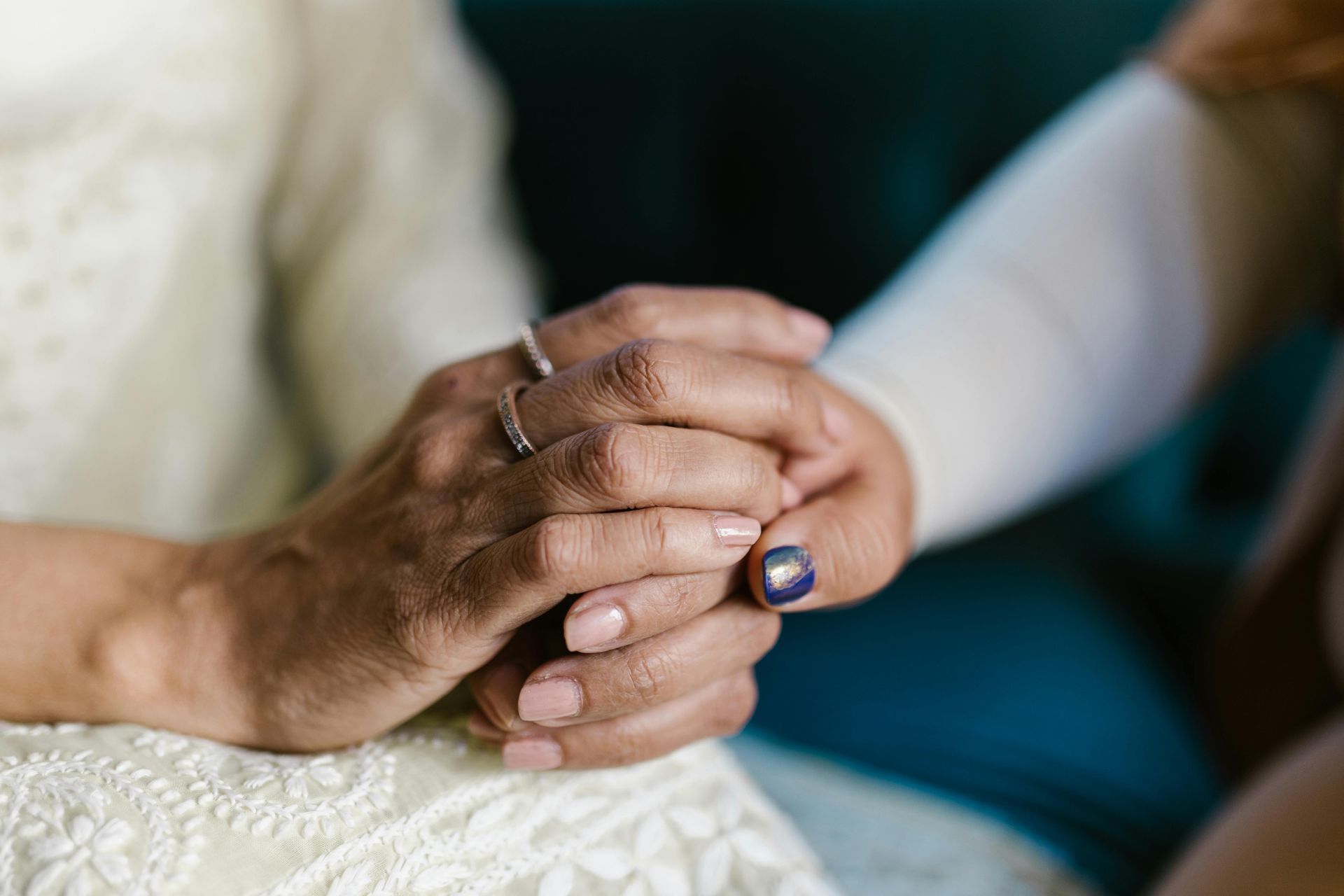 A close up of a person holding another person 's hand.