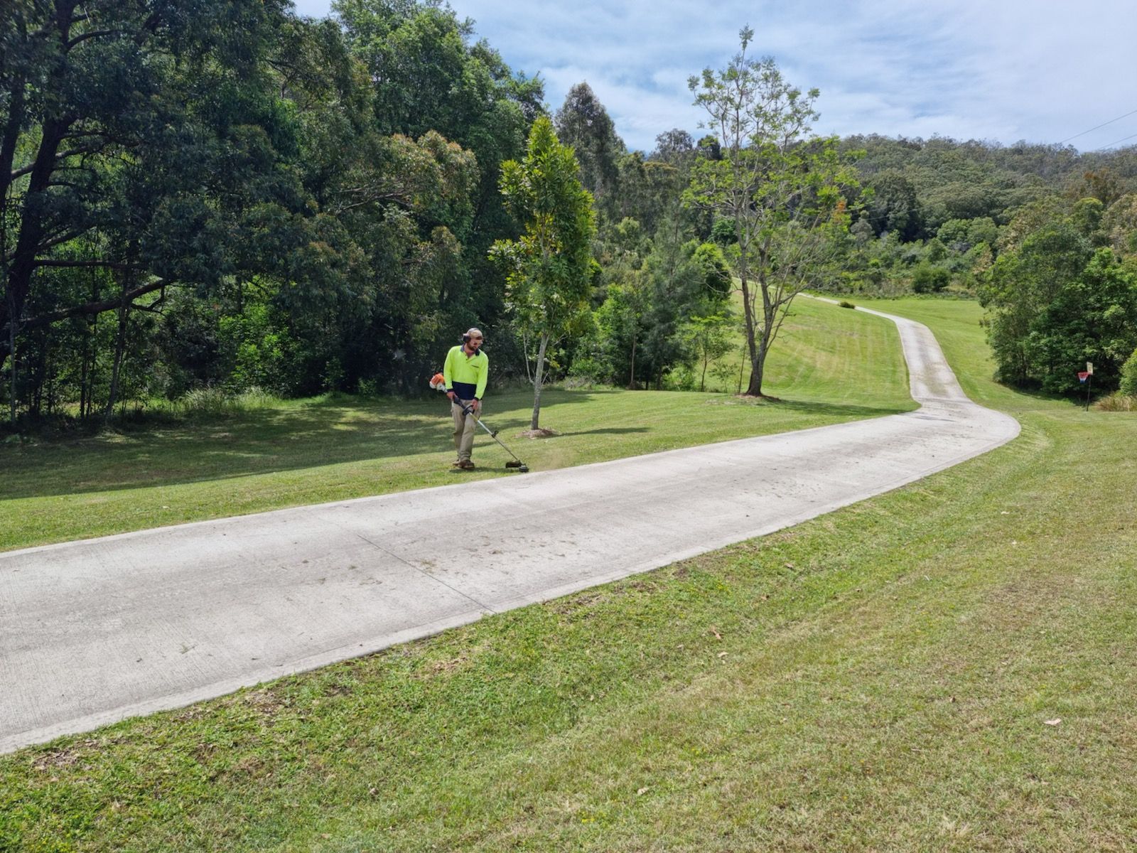 man slashing footpath side — Gardeners In Singleton, NSW
