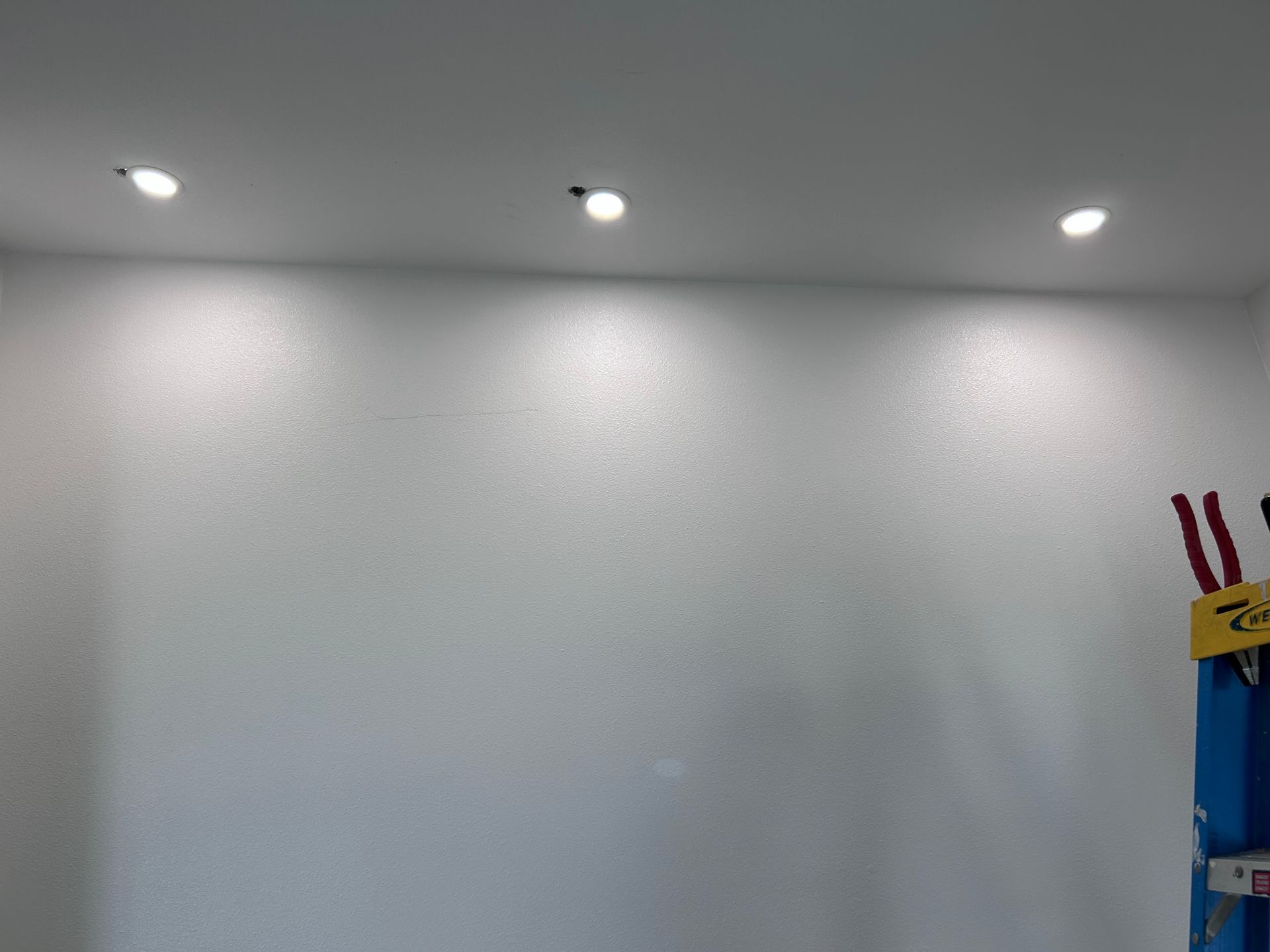 Person in gloves using a screwdriver to work on electrical components.