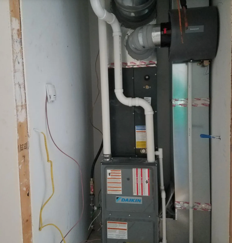 Living room with a fireplace, TV, ceiling fan, and art on the walls. Light brown carpet and neutral walls.