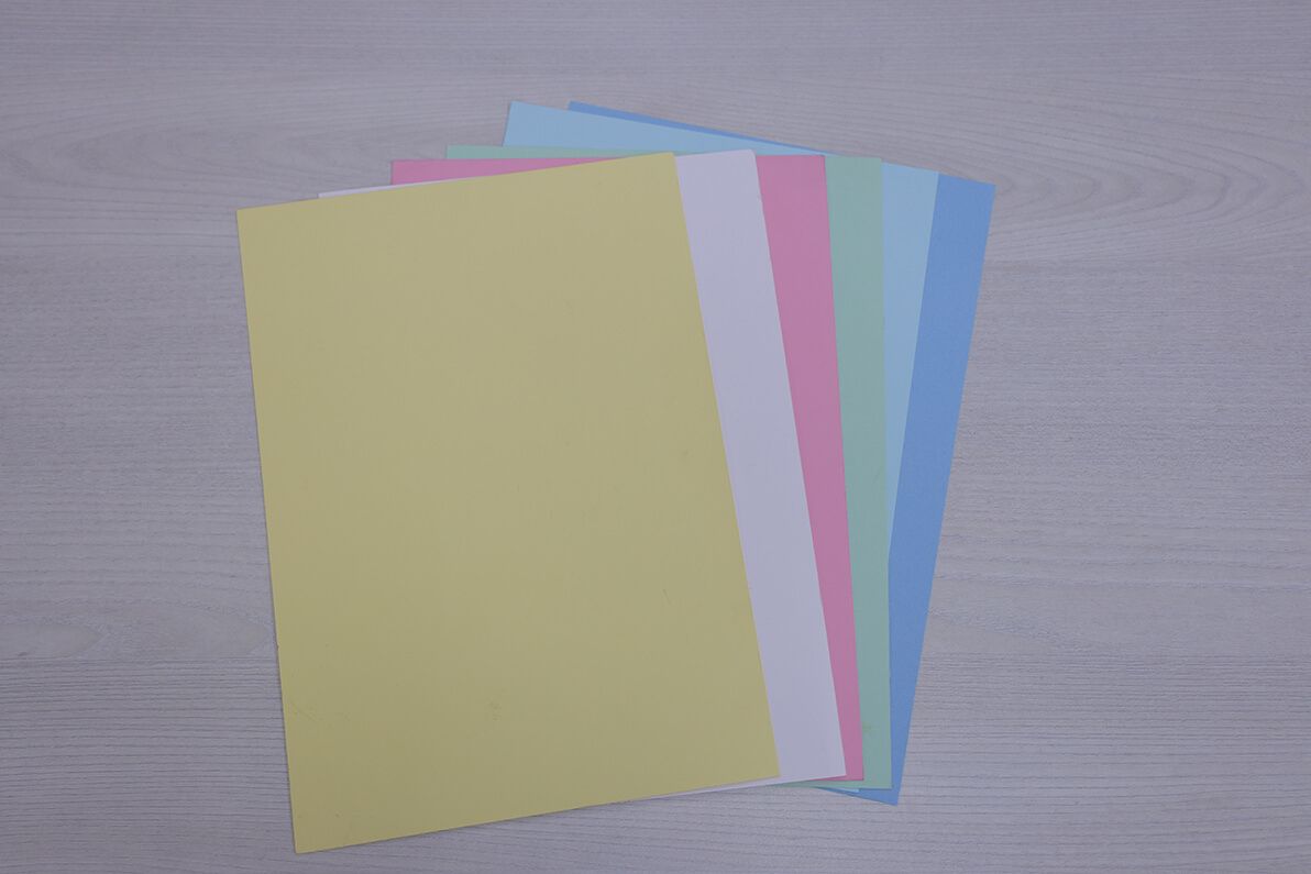 A bunch of different colored sheets of paper on a table