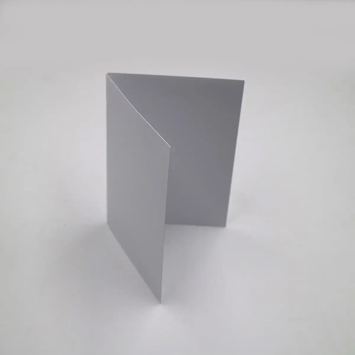 Gray folded card, standing open on a white surface.