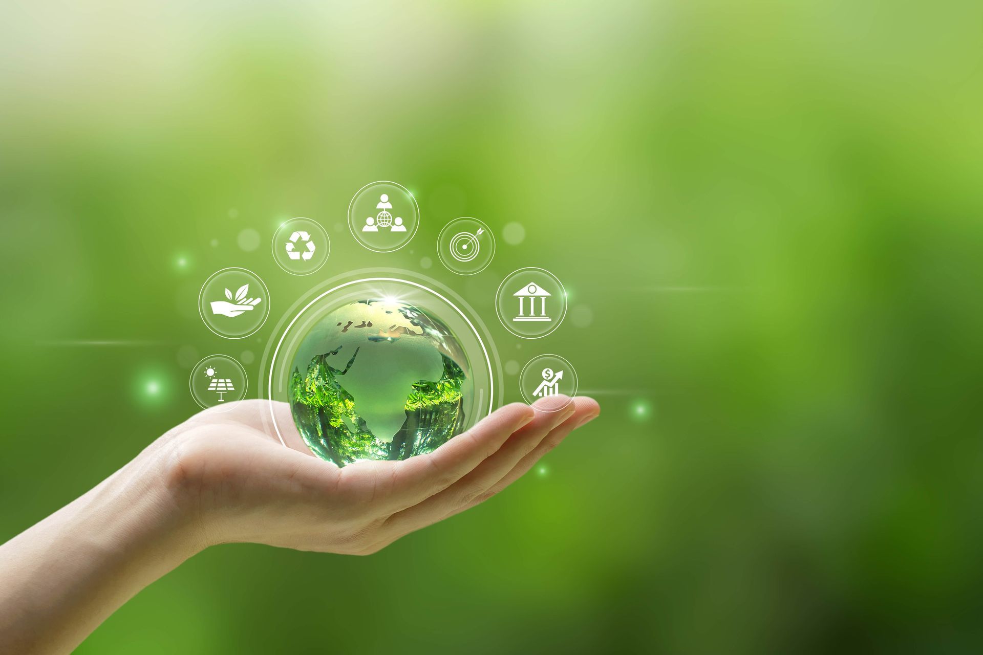 A person is holding a globe in their hand with icons around it.