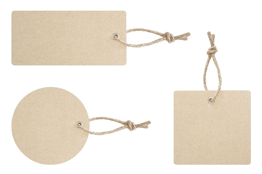 Three cardboard tags with ropes attached to them on a white background