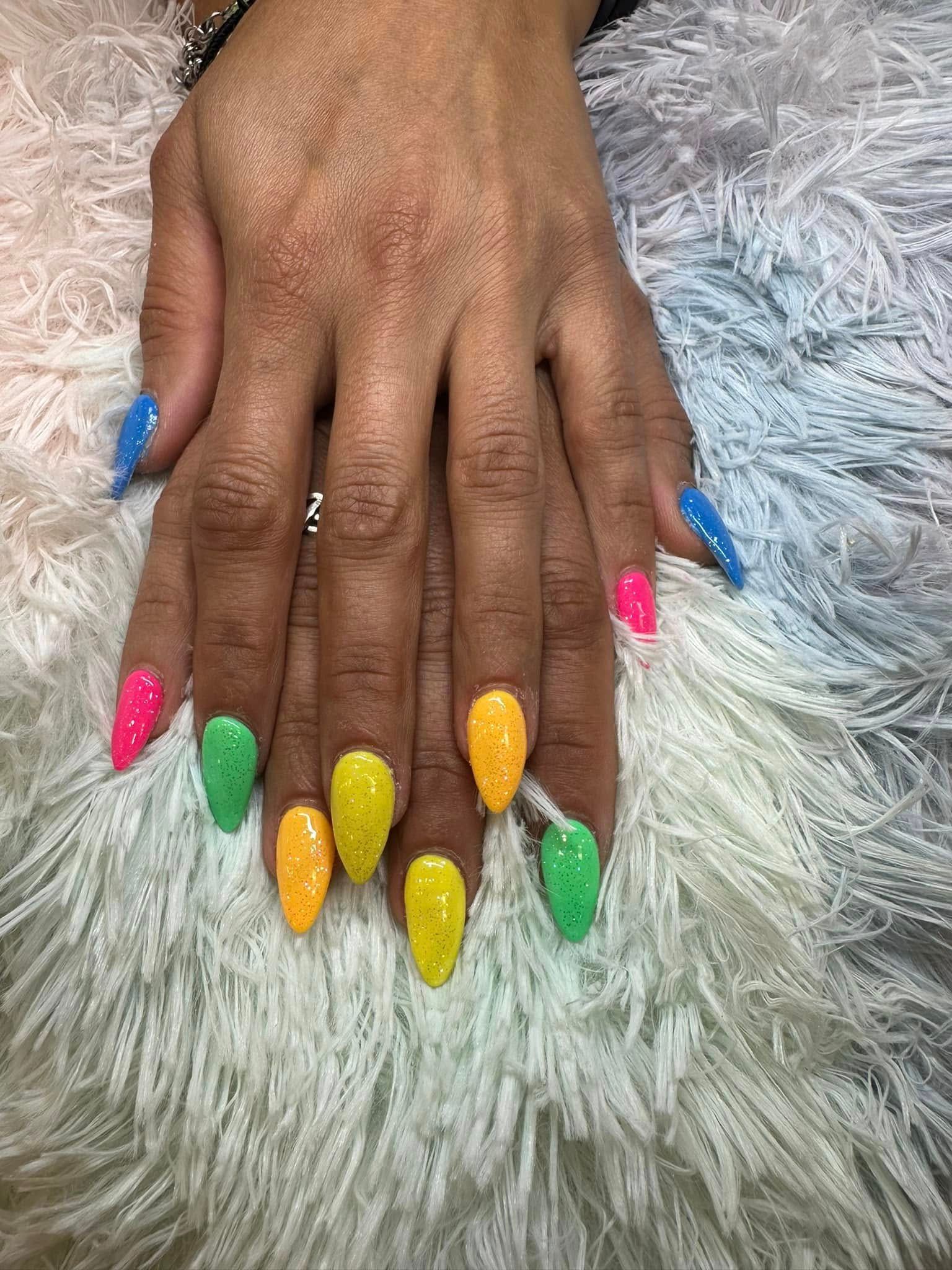 Hands displaying a manicure with almond-shaped nails, each painted a different neon color with a fine glitter finish.
