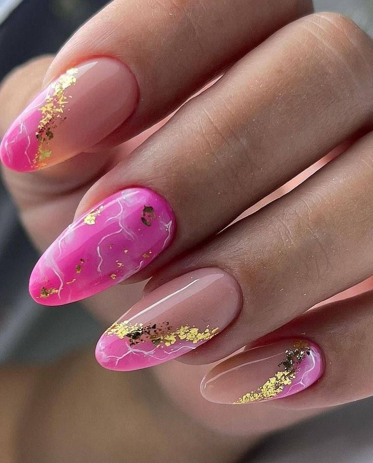 Oval-shaped nails with a pink and nude gradient, featuring gold leaf accents and subtle marble-like white veining.