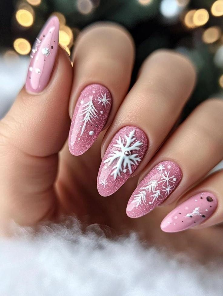Almond-shaped pink glitter nails with hand-painted white snowflakes and winter tree designs.