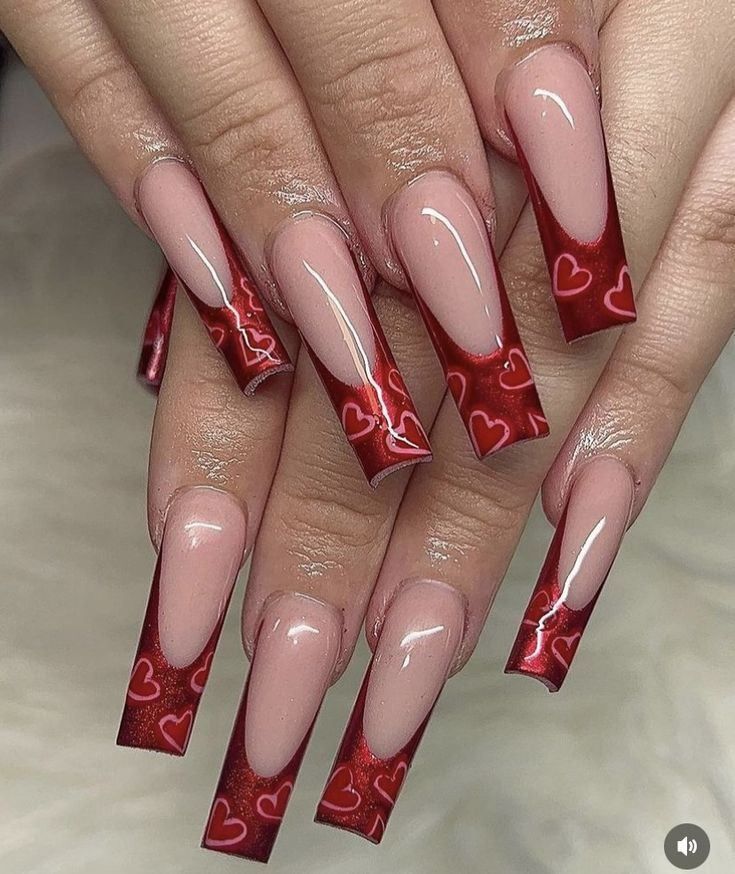 Long, square-shaped nails with a pink base and deep red French tips featuring a subtle, repeating heart pattern.