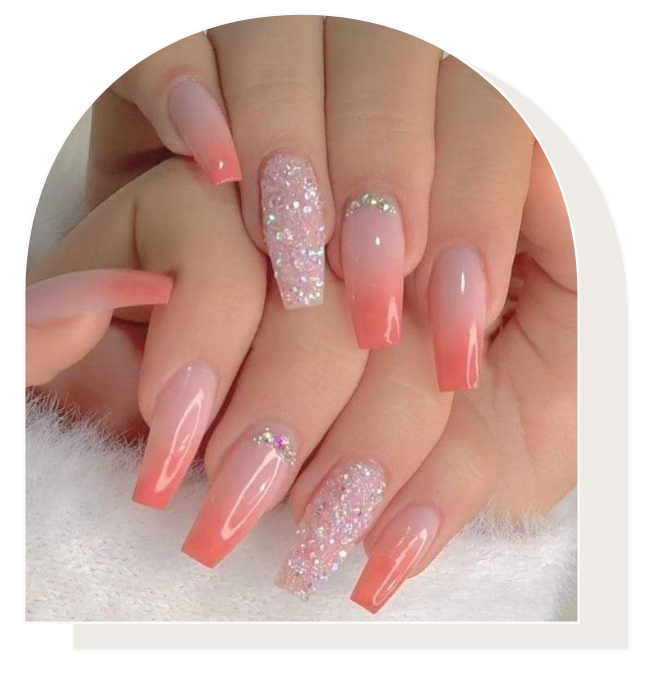 Two hands showing long, coffin-shaped nails with a peach ombre design, glitter accents, and rhinestone embellishments.