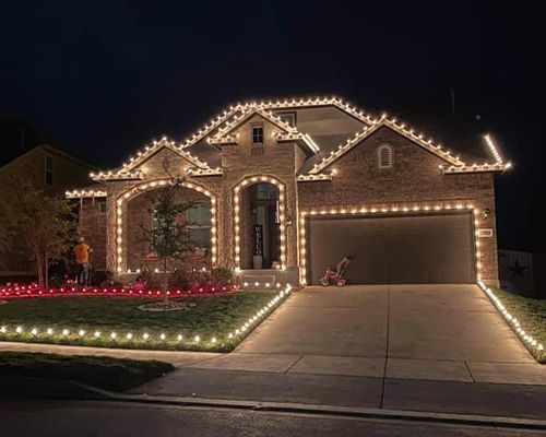 A house is decorated with christmas lights at night.