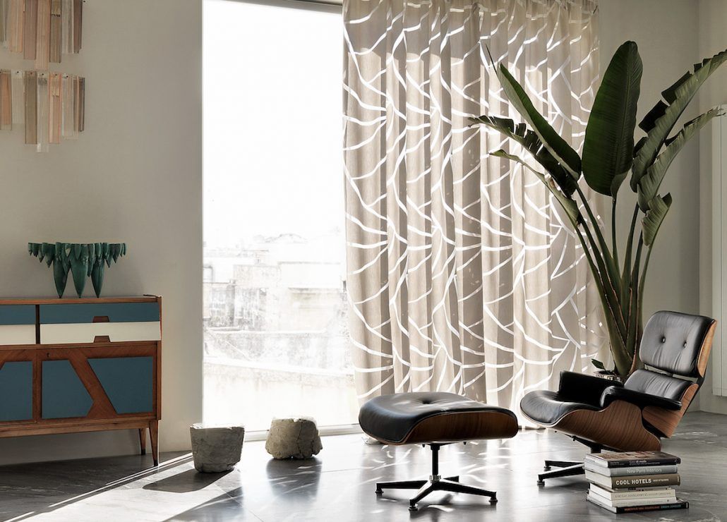 Un soggiorno con una sedia, un pouf e una pianta