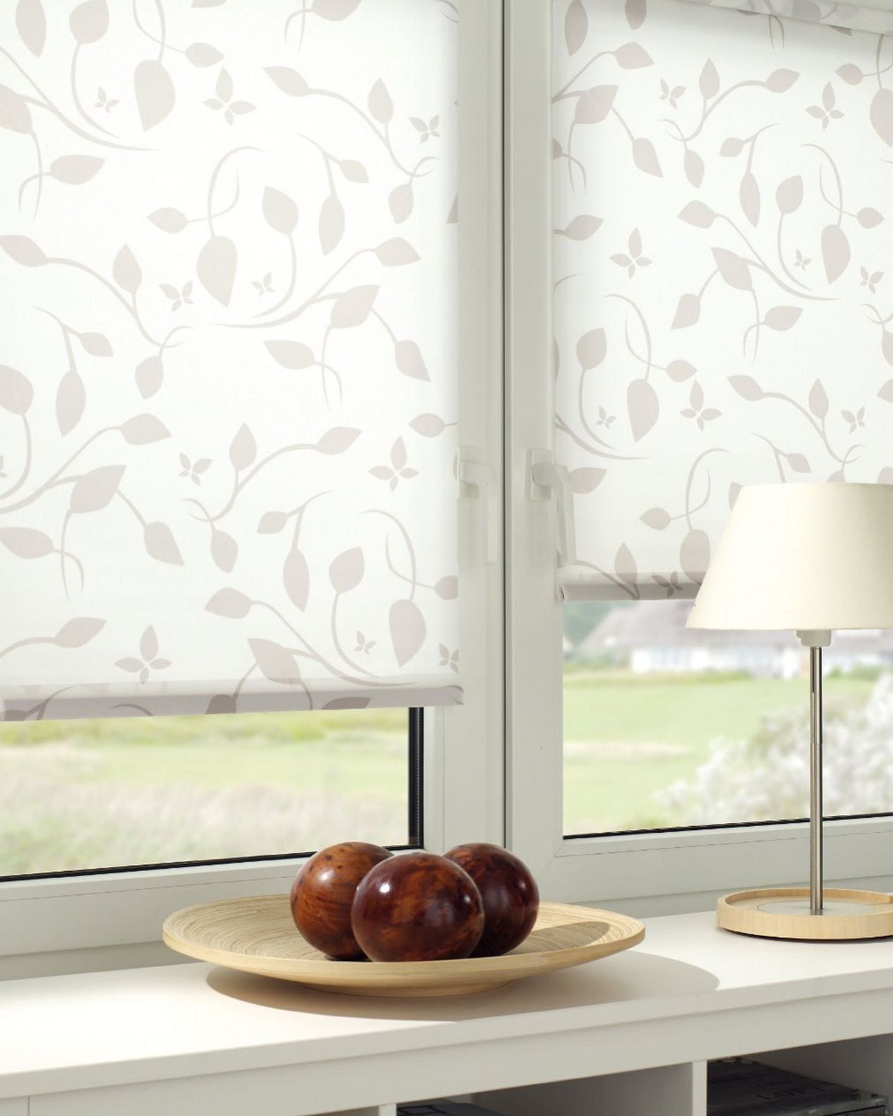 Una ciotola di mele è appoggiata sul davanzale di una finestra accanto a una lampada.