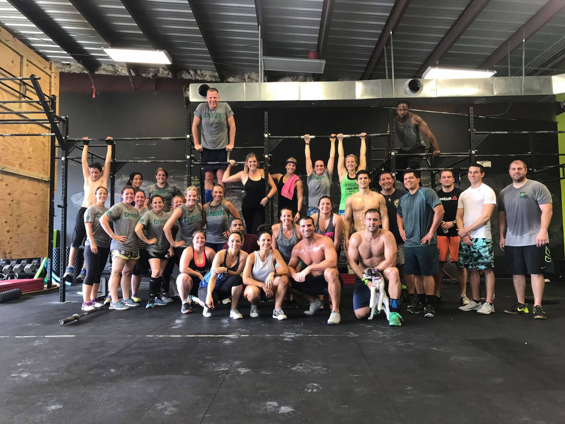 A group of people are posing for a picture in a gym.