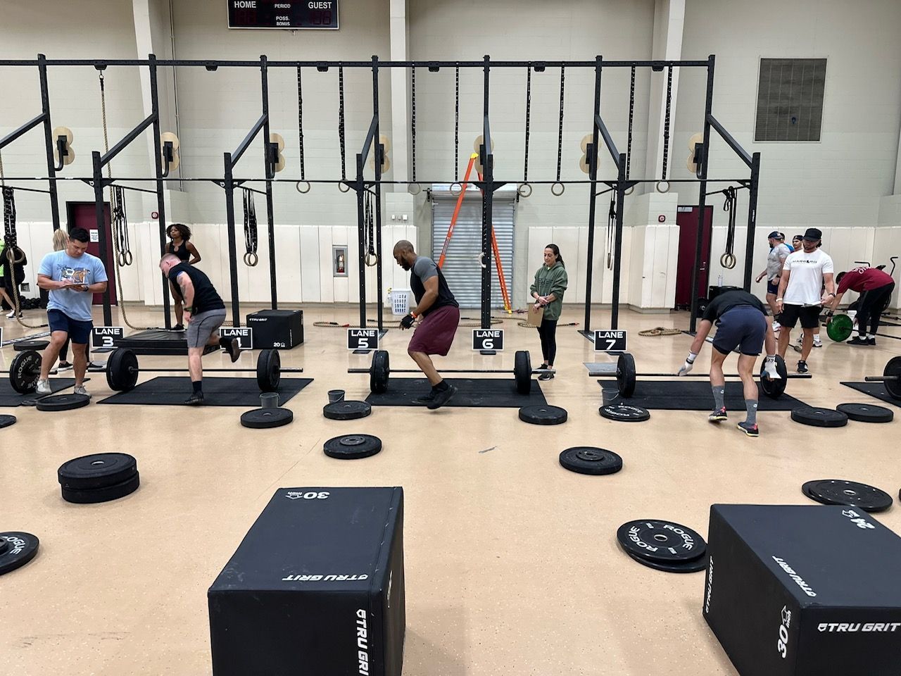 A group of people are lifting weights in a gym.