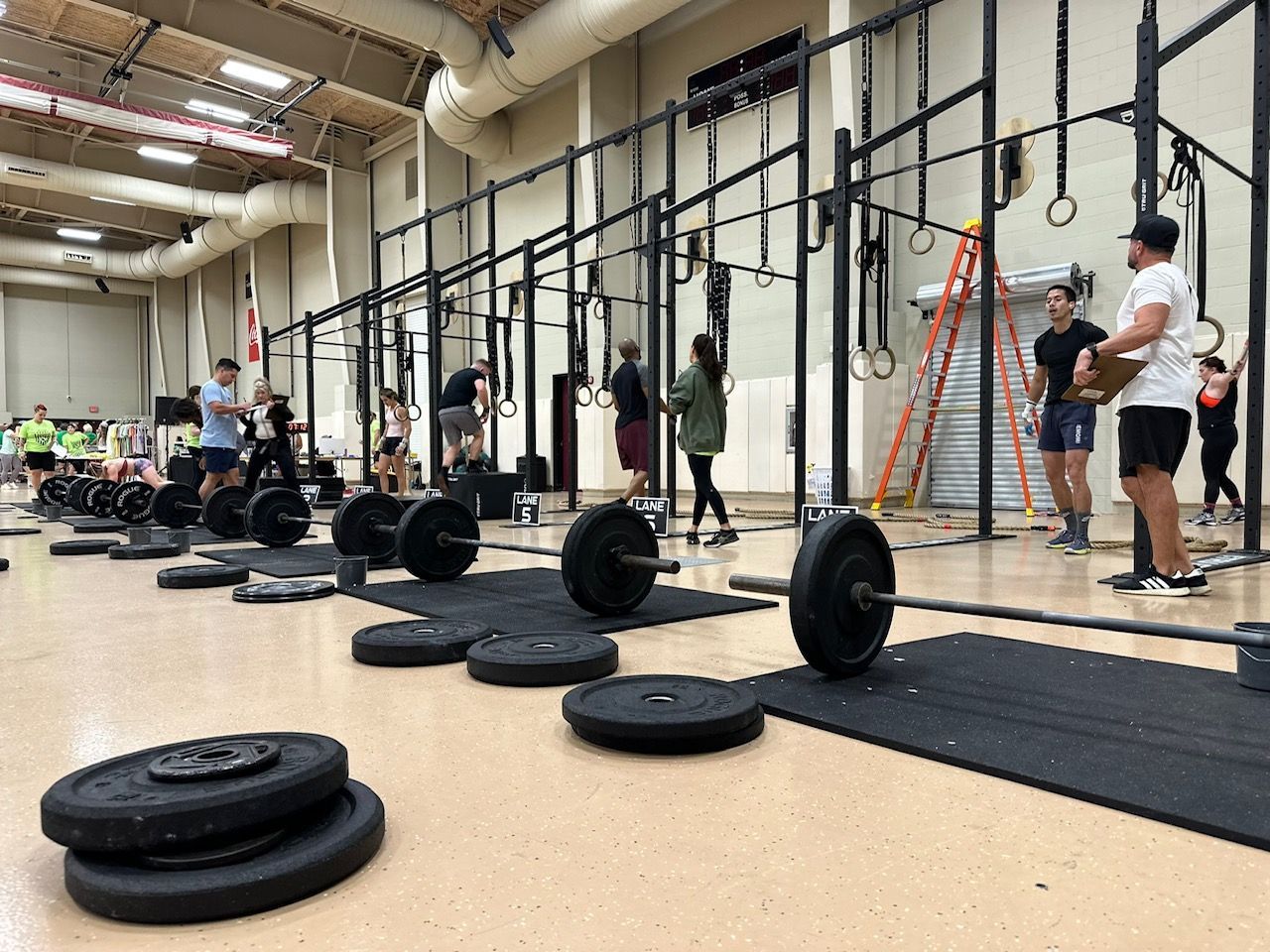A group of people are lifting weights in a gym.