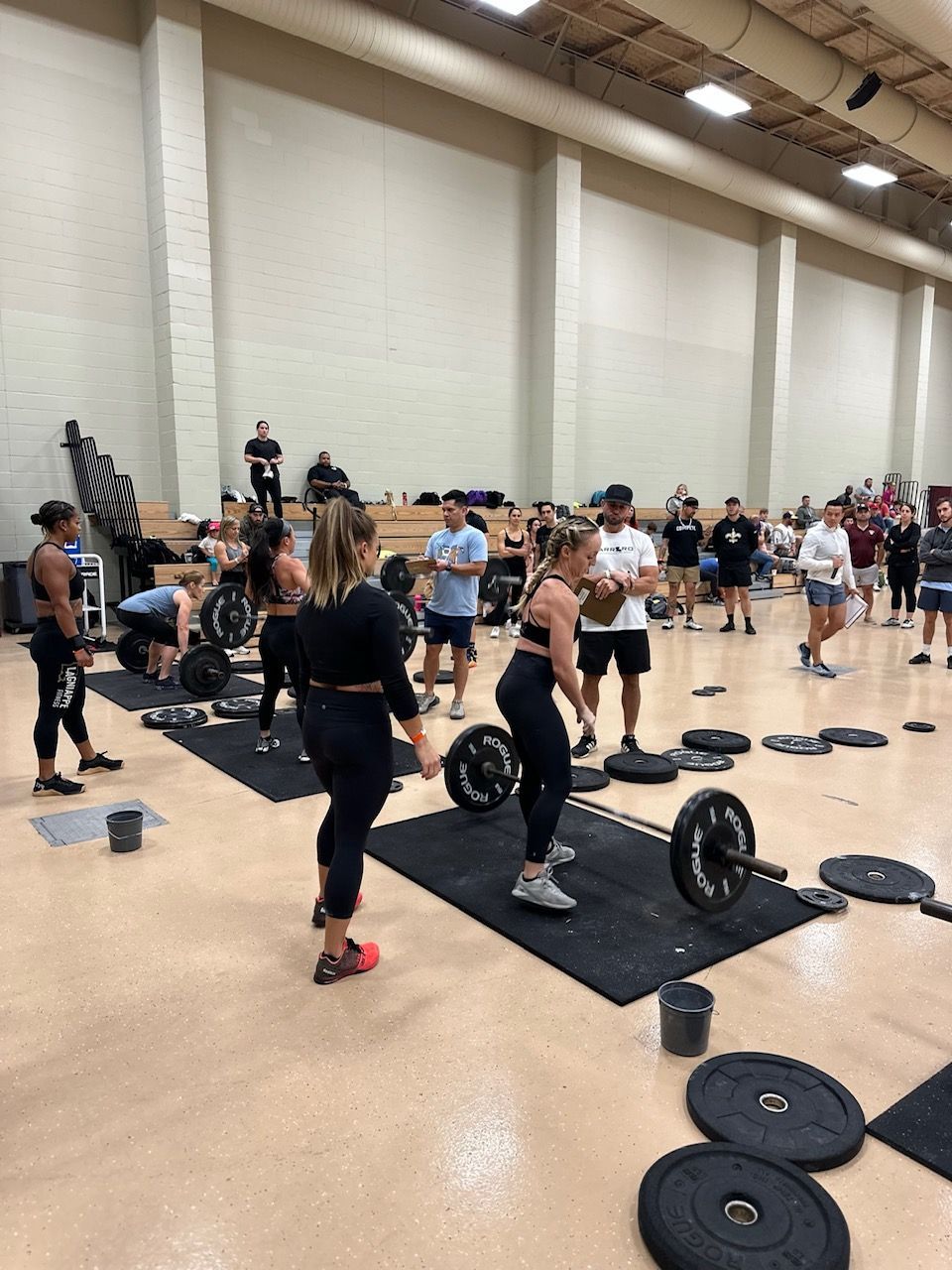 A group of people are lifting weights in a gym.