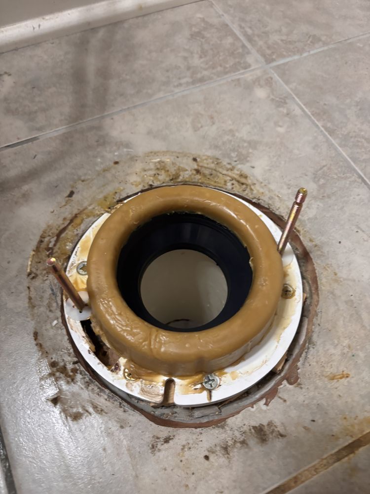 Toilet flange with a wax ring on a tile floor, ready for toilet installation.