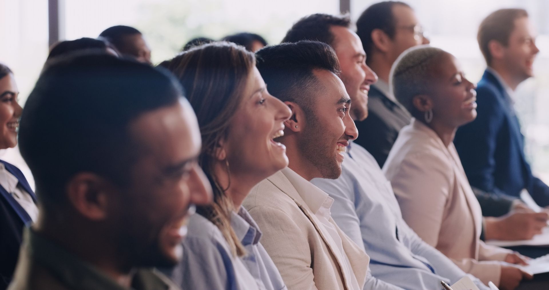Audience in a conference laughing and smiling