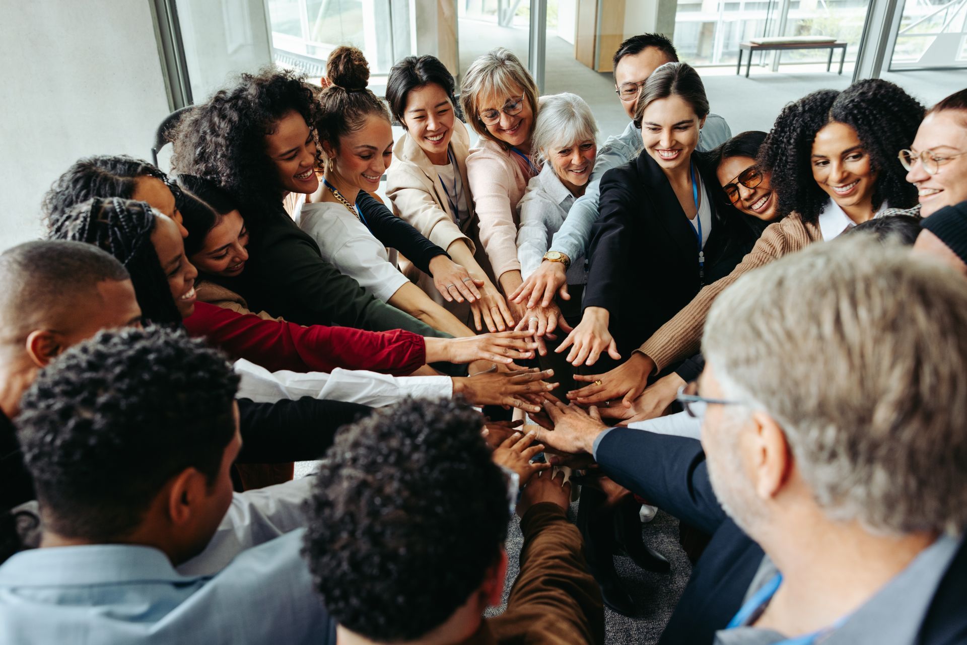 Diverse group of people with hands stacked together in a circle