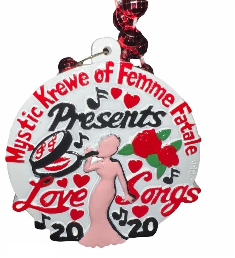 A medal that says mystic krewe of femme fatale presents love songs