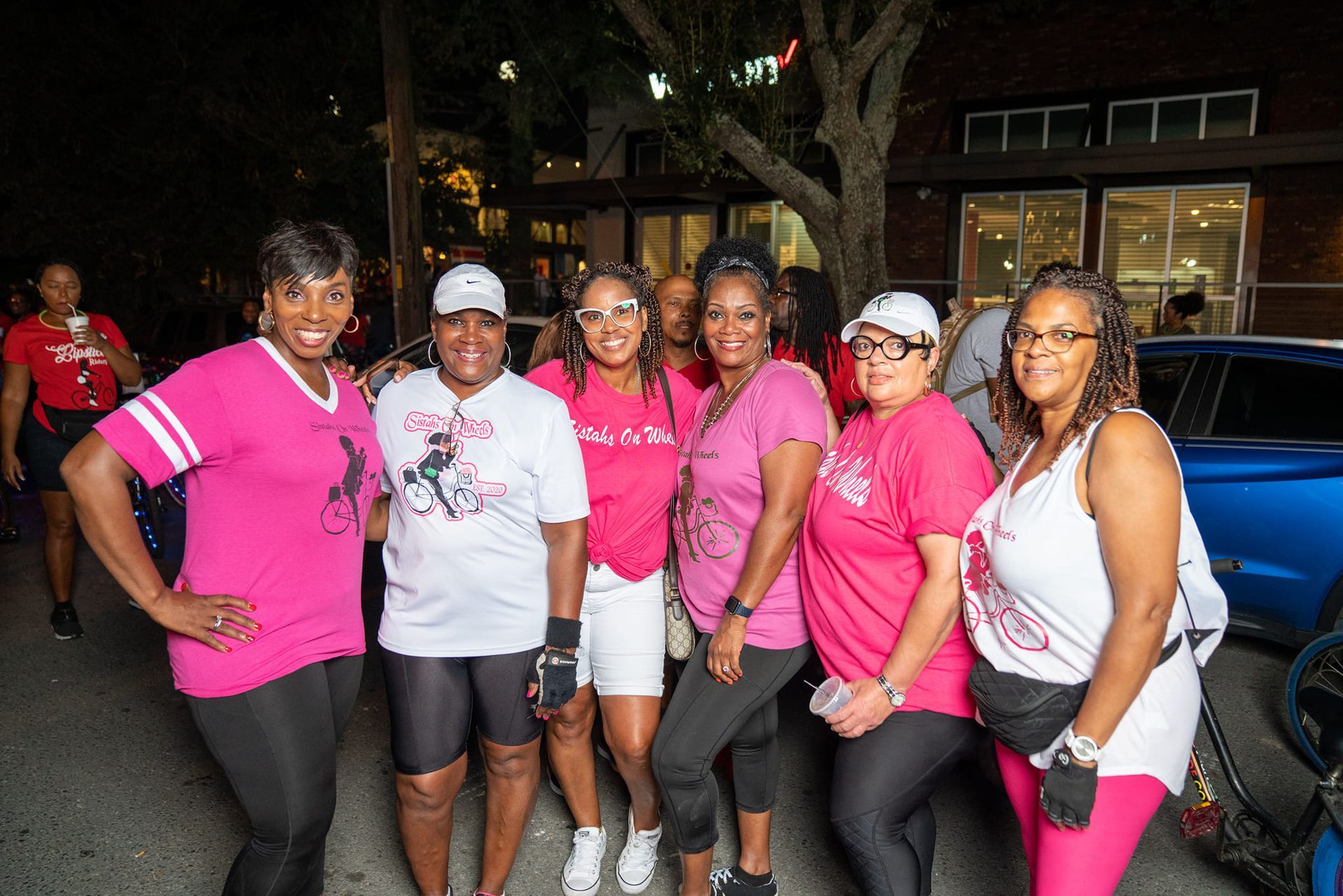A group of women in pink shirts are posing for a picture.