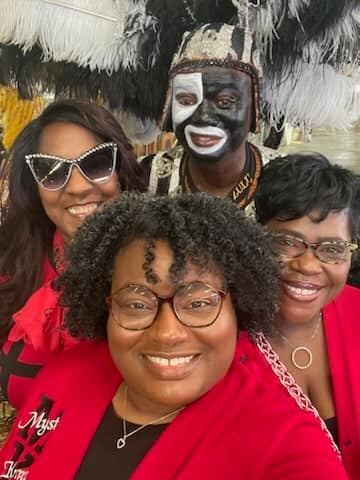 A group of people posing for a picture with one wearing a mask on his face.
