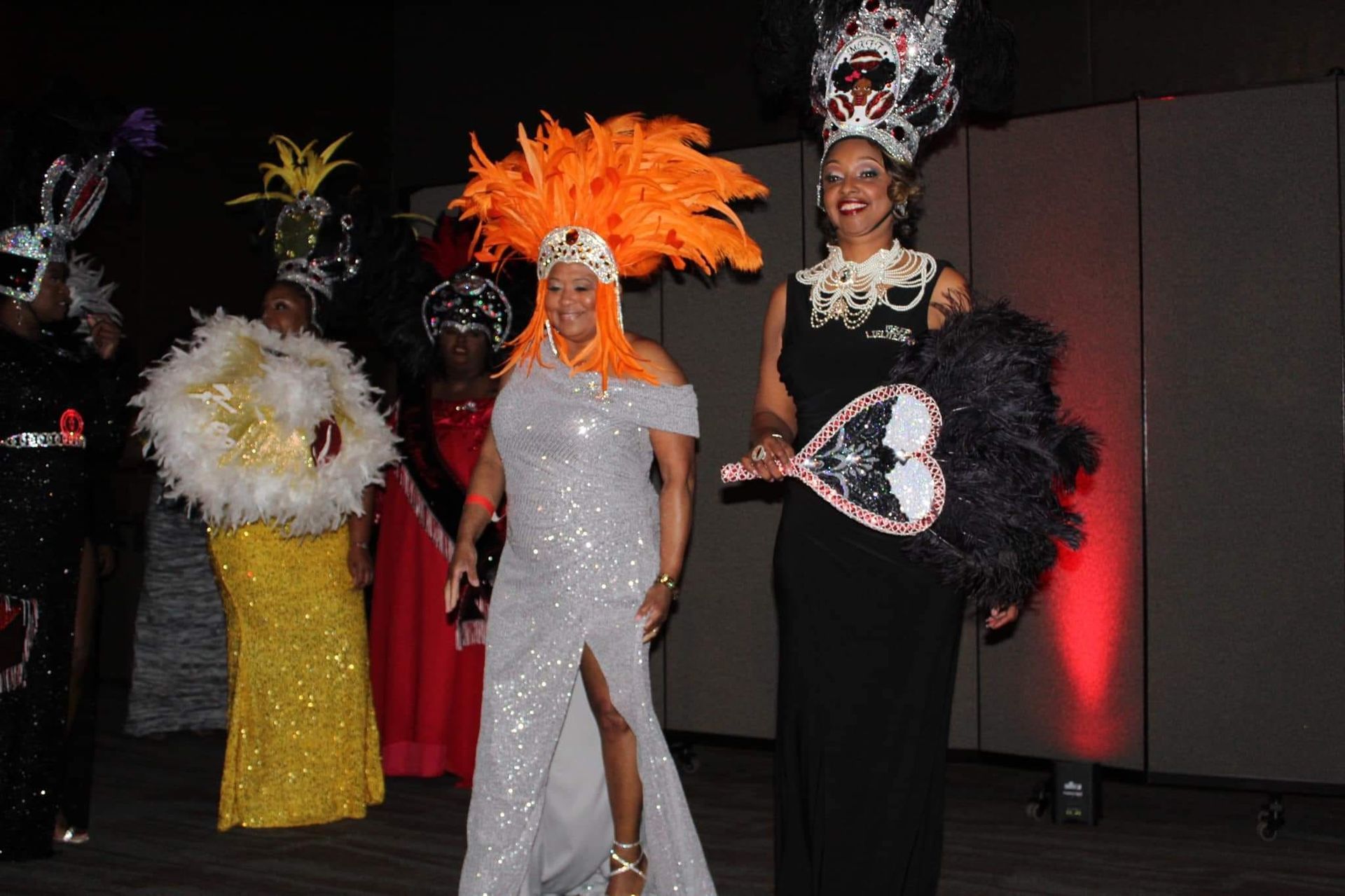A group of women dressed in carnival costumes are standing on a stage.