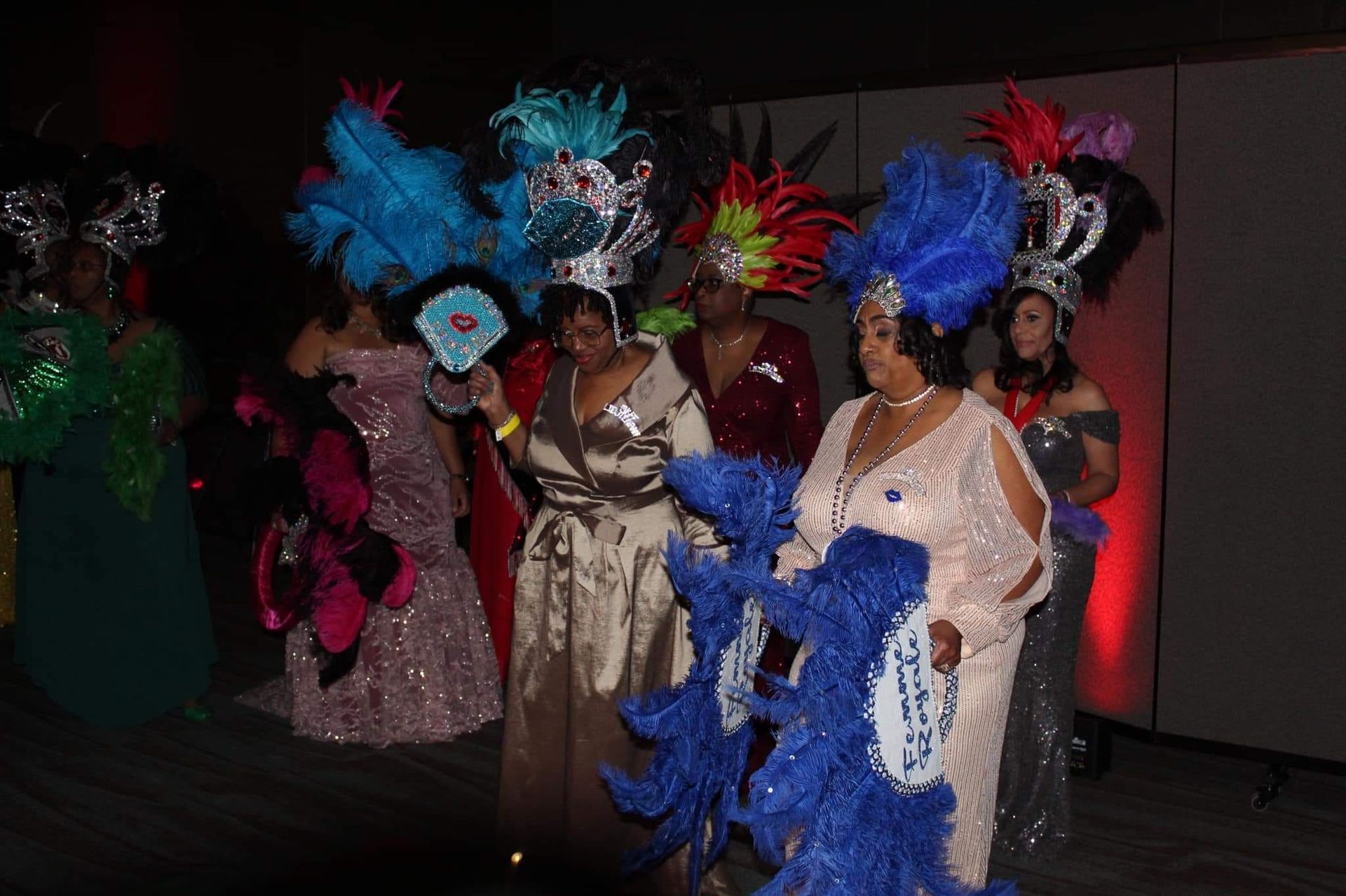 A group of women dressed in colorful costumes are standing next to each other.