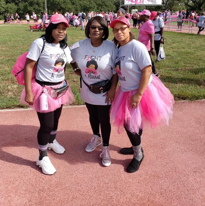 Three women wearing pink tutus and shirts that say fight breast cancer
