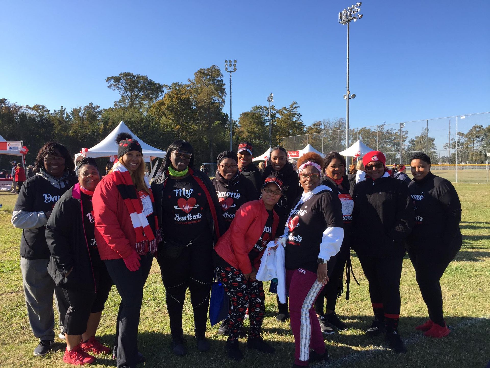 A group of women are posing for a picture in a field.