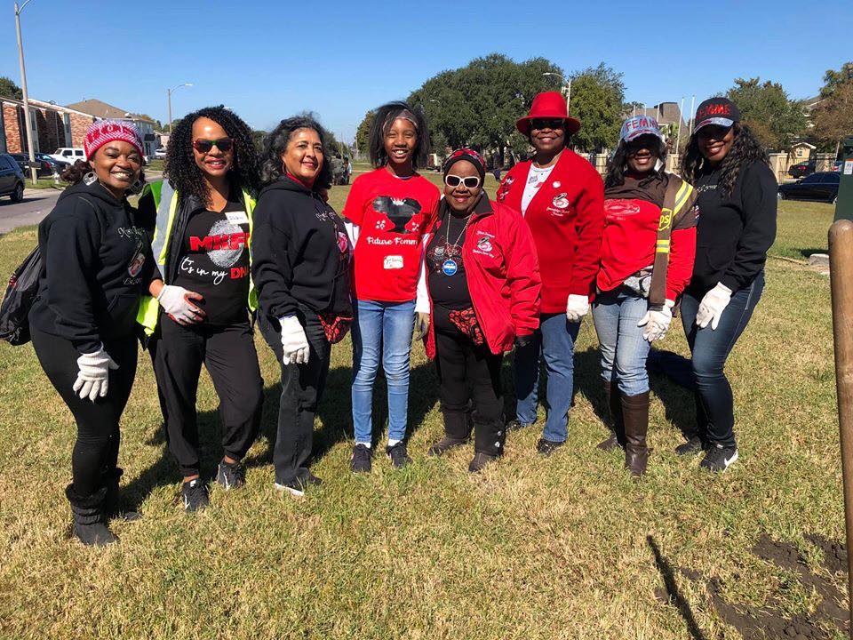 A group of women are standing in a grassy field.
