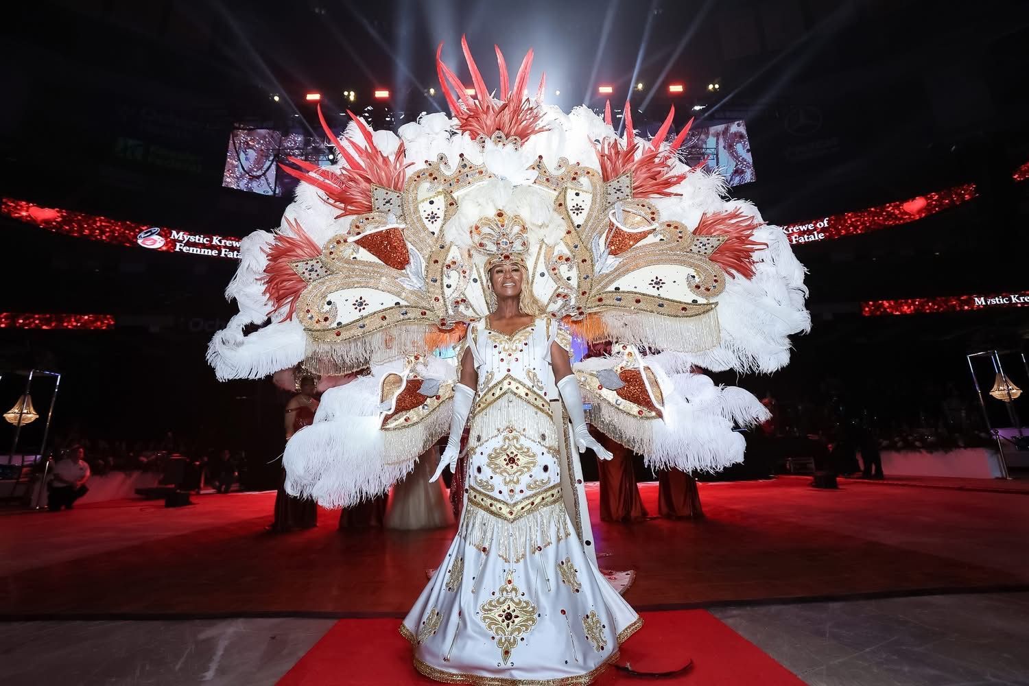 A woman in a white dress and gloves is wearing a tiara