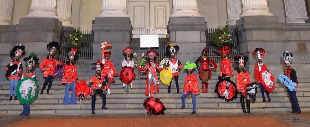 A group of people are standing on the steps of a building.