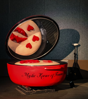 A woman wearing a red dress and a pearl necklace is smiling for the camera.