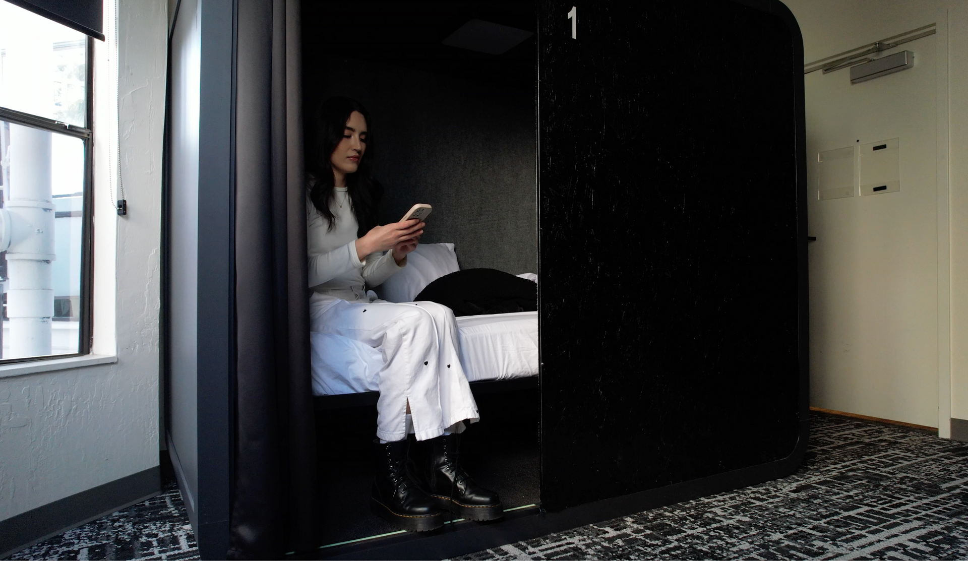 Hallway with black cabinets and patterned floor; a black chair sits on the right.