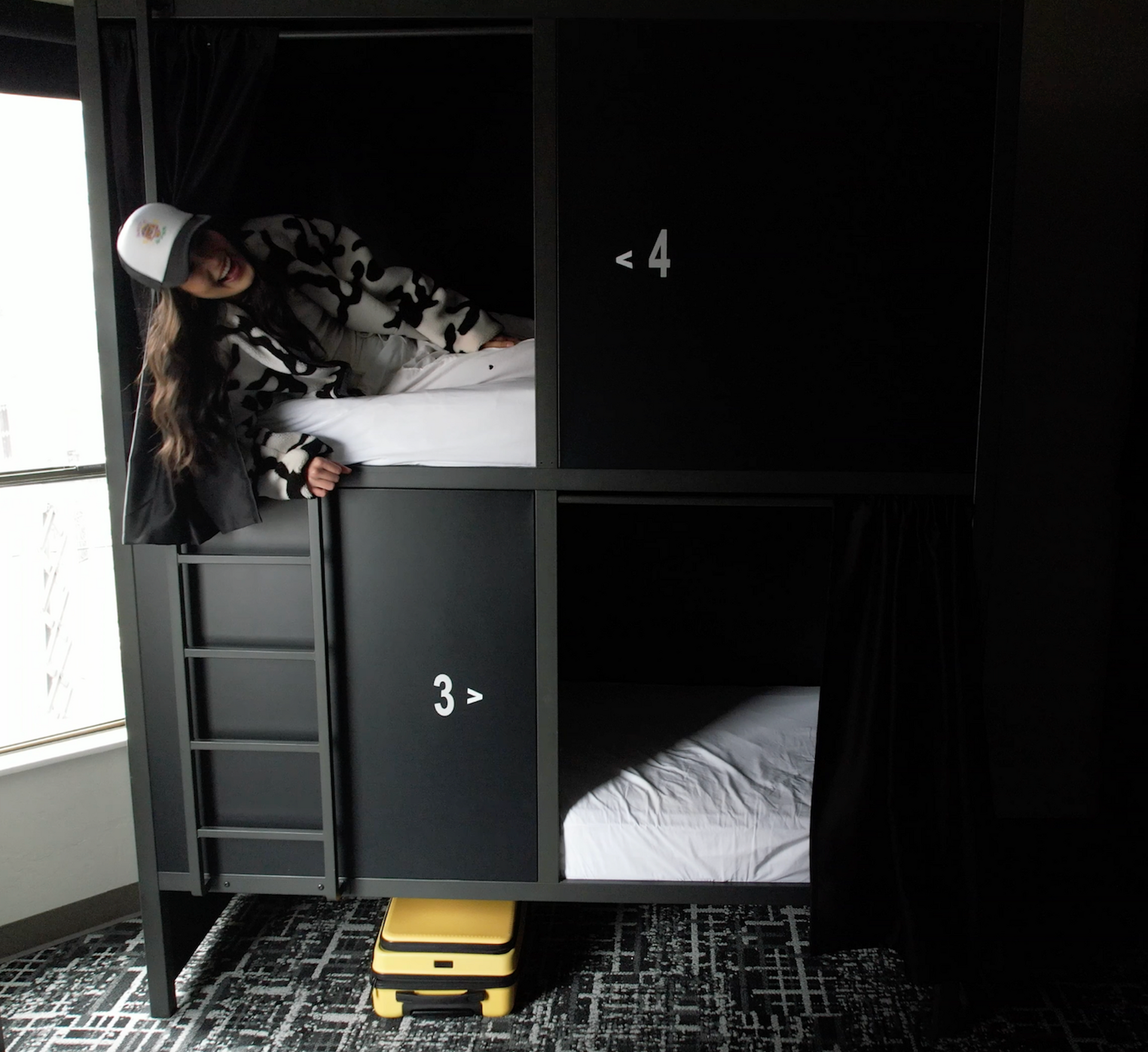 A person in a bunk bed, inside a dark room. Number 