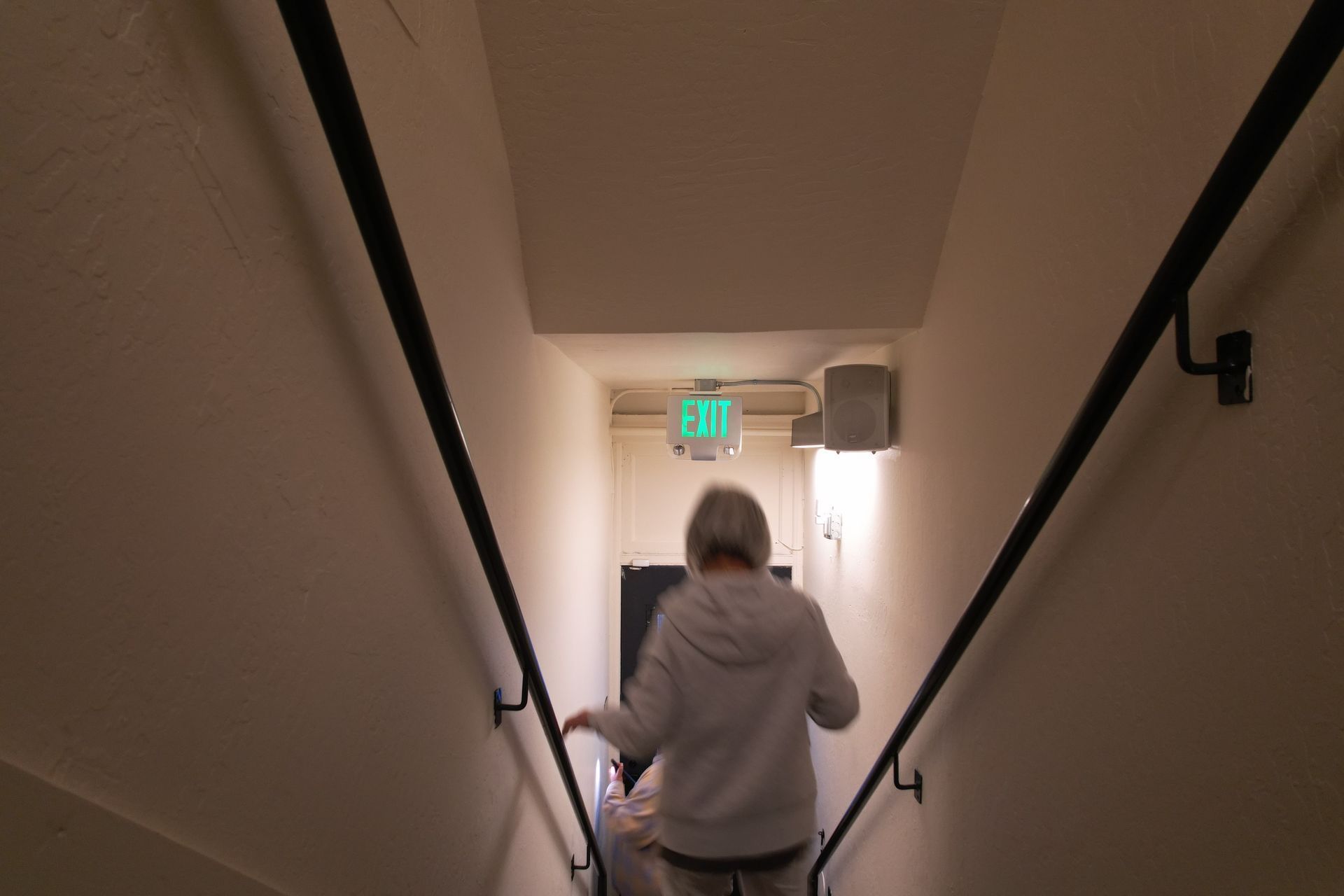 Person walking up a stairwell, towards an 