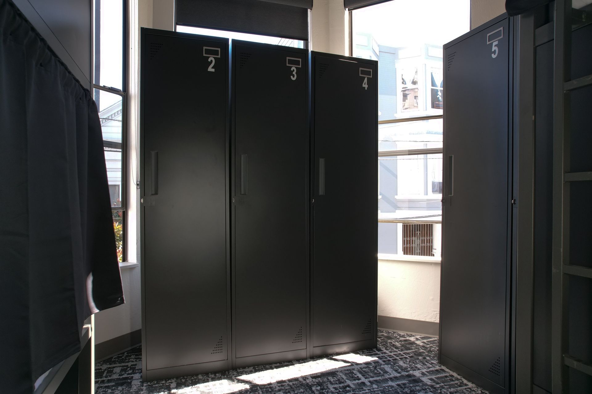 Dark gray lockers numbered 2, 3, and 5 in a room with a window.