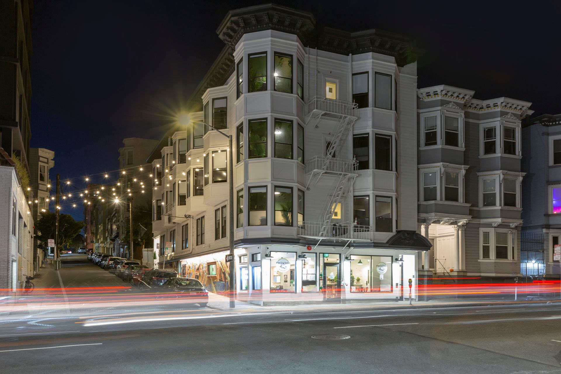 Woman unlocking a door, holding a key, standing with luggage on steps next to a mailbox.