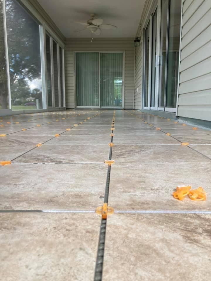 A tiled porch with a sliding glass door and a ceiling fan.