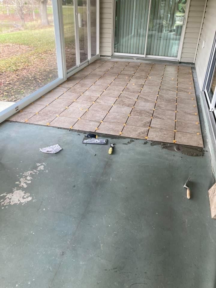 A patio is being built on a screened in porch.